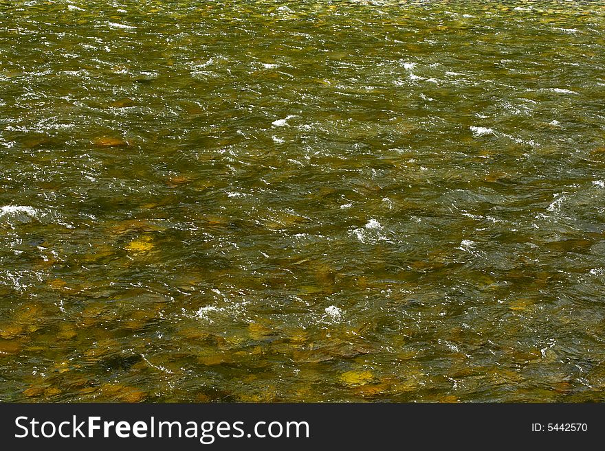 Natural texture. Pure river transparent water with a visible stony bottom - can be used as abstract background. Variant four. Natural texture. Pure river transparent water with a visible stony bottom - can be used as abstract background. Variant four.