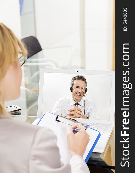 Businessman having laptop conference call with colleague. Businessman having laptop conference call with colleague.