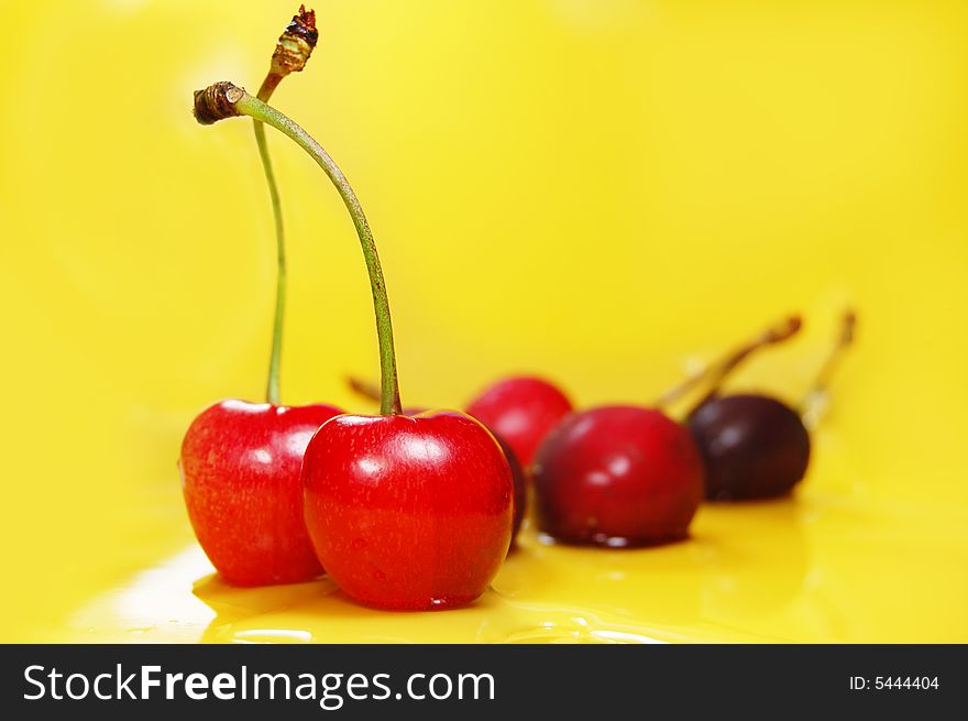 Red cherries on yellow background