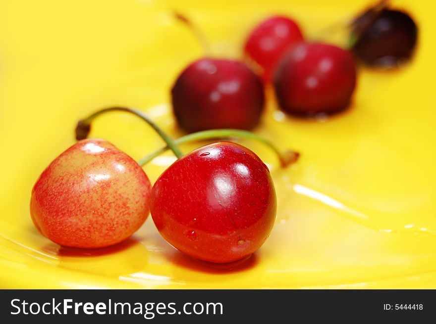 Red cherries on yellow background
