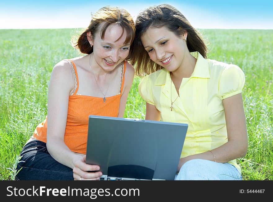 Two beautiful girls with laptop computer