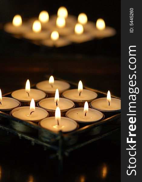 Photo of white candles with flames.