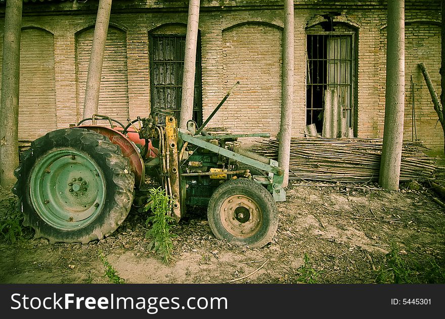 Abandoned tractor close to an old building. Abandoned tractor close to an old building.