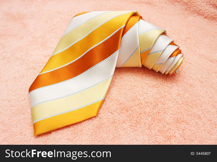 A rolled up necktie on cotton cloth.
