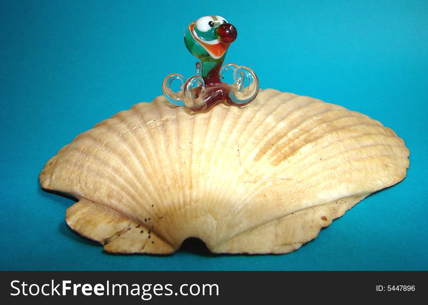 Toy glass octopus on pearls on a bowl of a Far East comb