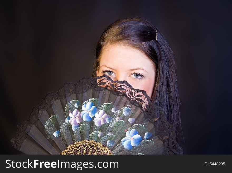 A portrait of an european teenager girl holding a fan. A portrait of an european teenager girl holding a fan