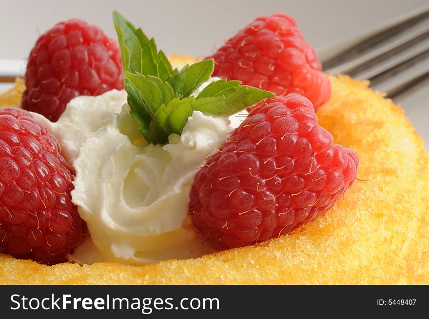 Fresh raspberries served with whipped cream on cake. Fresh raspberries served with whipped cream on cake.
