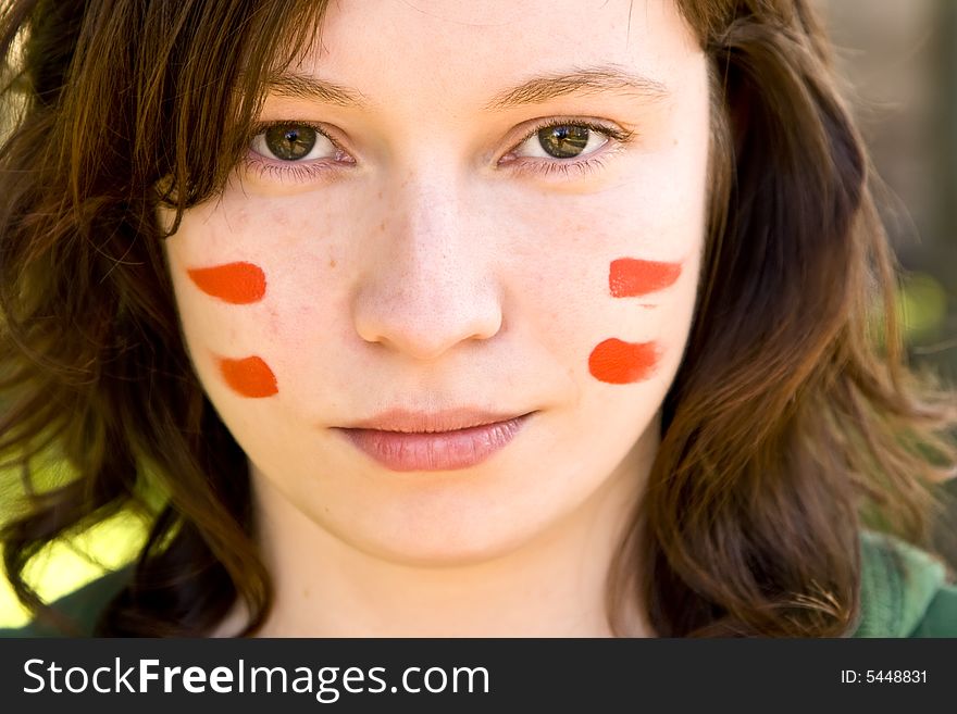 Sport fan with painted face, representing Austrian flag.