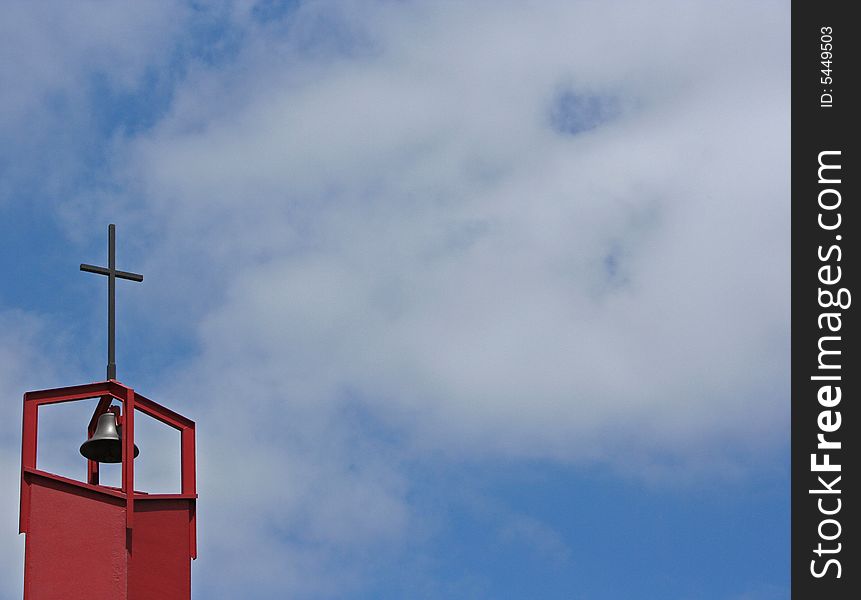 1970s church bell with scattered clouds in the background.