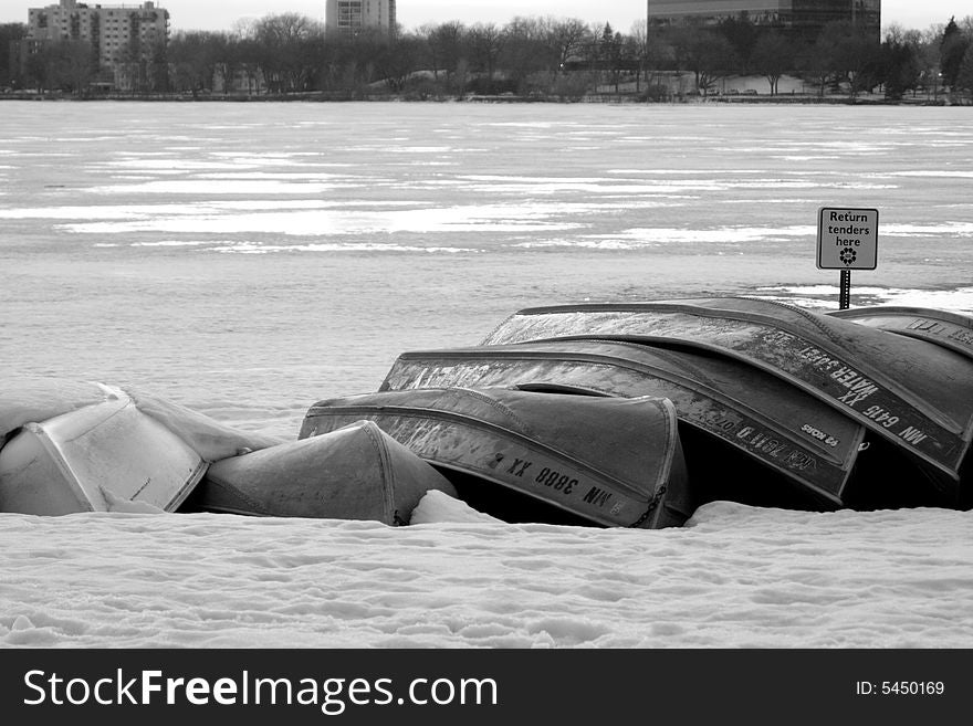 Upturned canoes during a Minnesota winter. The canoes a stacked on top of a frozen lake. Upturned canoes during a Minnesota winter. The canoes a stacked on top of a frozen lake.