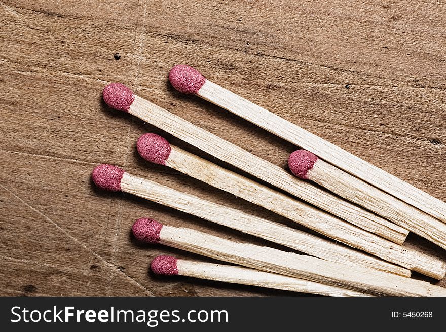 Matches on wooden surface. Detail.