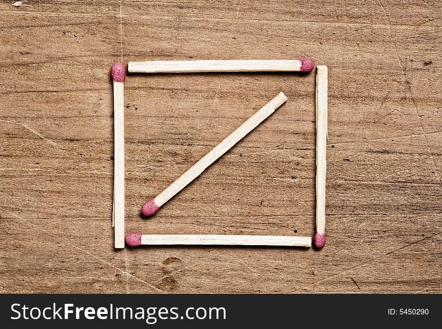 Matches on wooden surface forming a square shape.