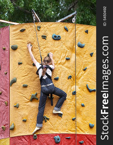Young girl climbs on training wall. Young girl climbs on training wall