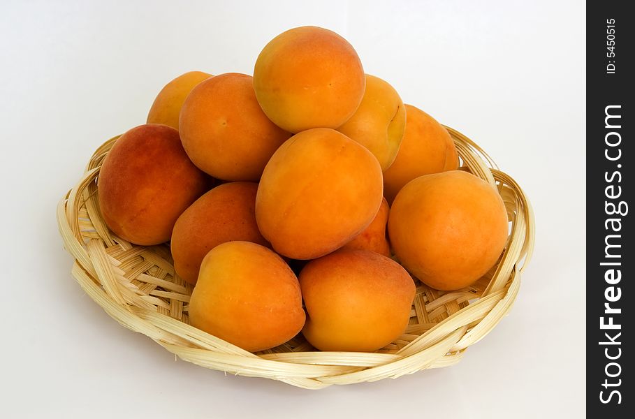 Ripe apricots in the wattled small basket from the arboreal shavings