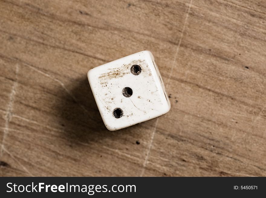 Old dice on wooden table.