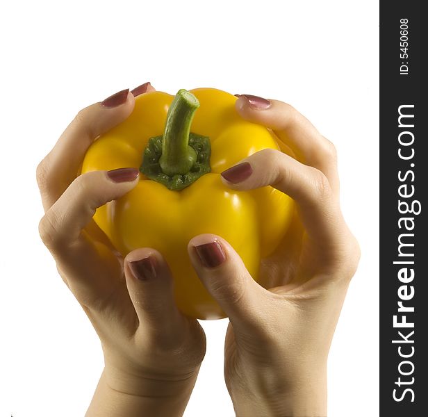 Yellow pepper in a womanish hand with violet nails