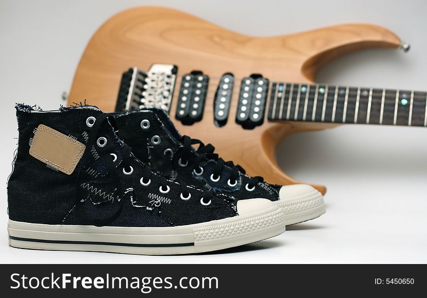 A pair of sneakers and an electric guitar. A pair of sneakers and an electric guitar