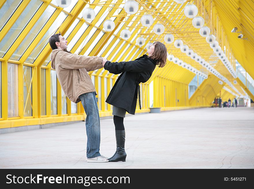 Boy and girl hold each other for  hands on  footbridge