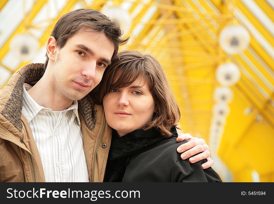 Boy embraces girl on yellow footbridge. Boy embraces girl on yellow footbridge