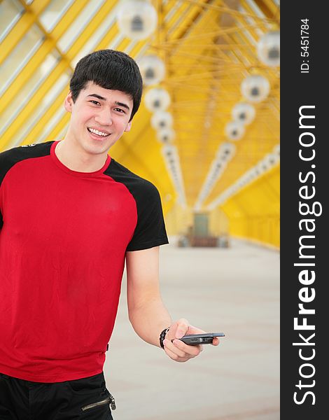 Young man with cell phone on footbridge