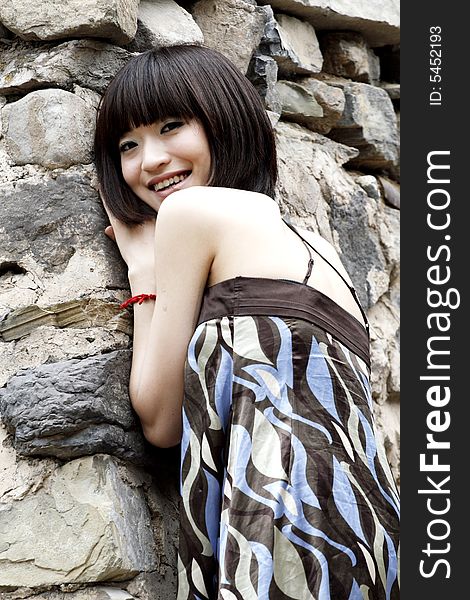 A girl standing next to a stone wall, here is one of China's ancient villages . A girl standing next to a stone wall, here is one of China's ancient villages .