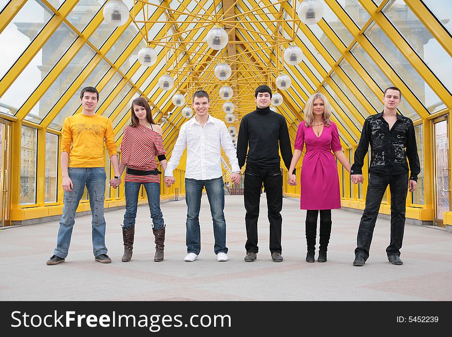 Group of friends it stand taking hands on footbridge