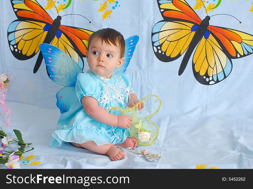 A picture of a sweet little girl in a fancy blue dress with butterfly wings. A picture of a sweet little girl in a fancy blue dress with butterfly wings