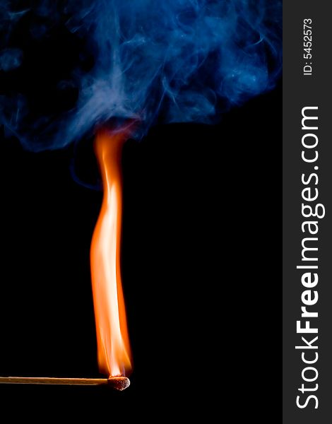 Match with a flame on dark background. Match with a flame on dark background