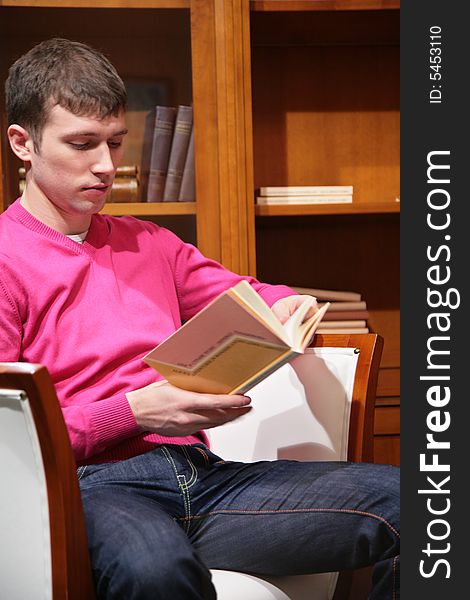 Young man reads book in room