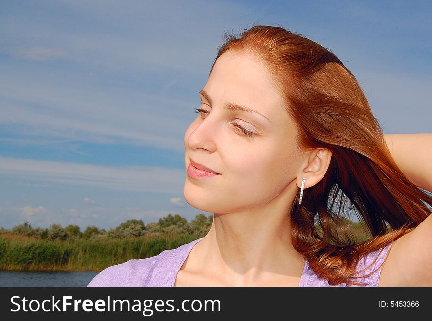 Beautiful young red hair girl against the sky. Beautiful young red hair girl against the sky