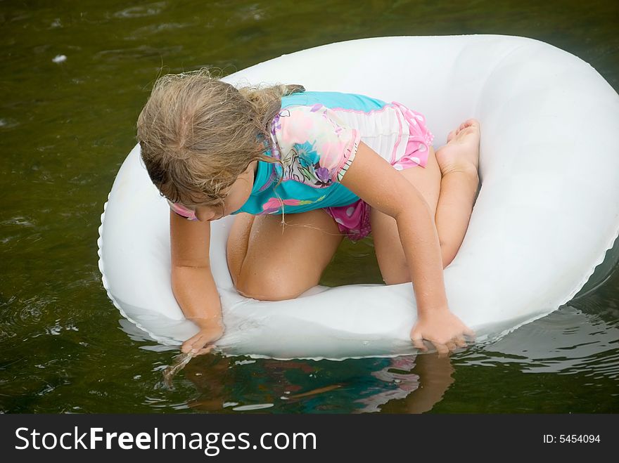 Young girl playing in a tube on the water. Young girl playing in a tube on the water.