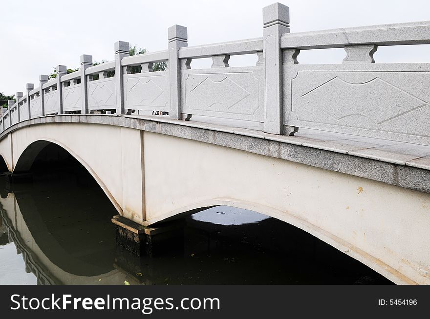 A small stone bridge in a Chinese city park. A small stone bridge in a Chinese city park.