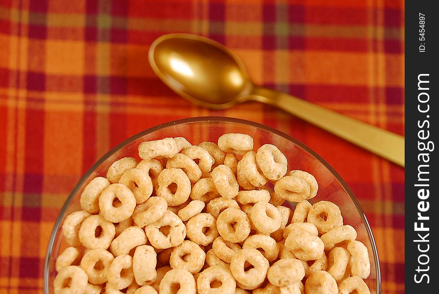 Bowl of breakfast cereal on plaid background with spoon. Bowl of breakfast cereal on plaid background with spoon