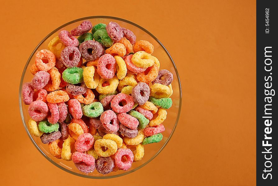 Bowl of colourful cereal on brown background