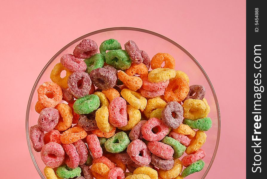 Bowl of colourful cereal on pink background