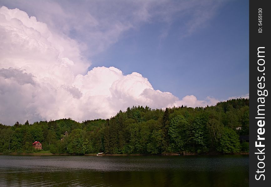 Big and brightly clouds above mountain lake. Big and brightly clouds above mountain lake