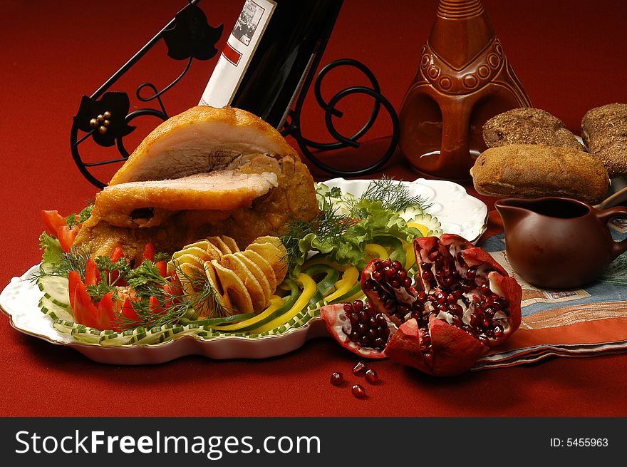 Fried meat with a pomegranate on a red background
