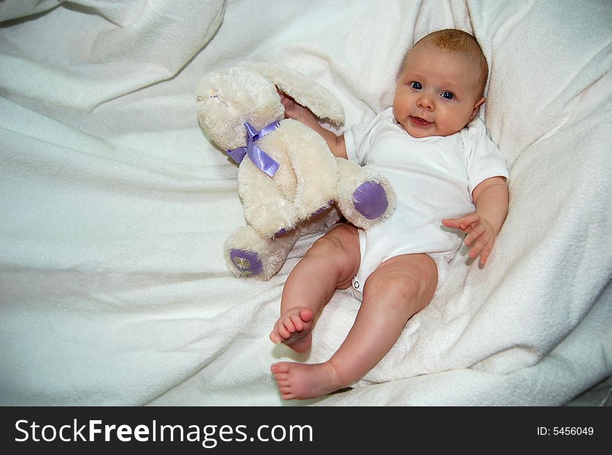 Lovely baby with  blue eyes, palming bunny - toy. Lovely baby with  blue eyes, palming bunny - toy