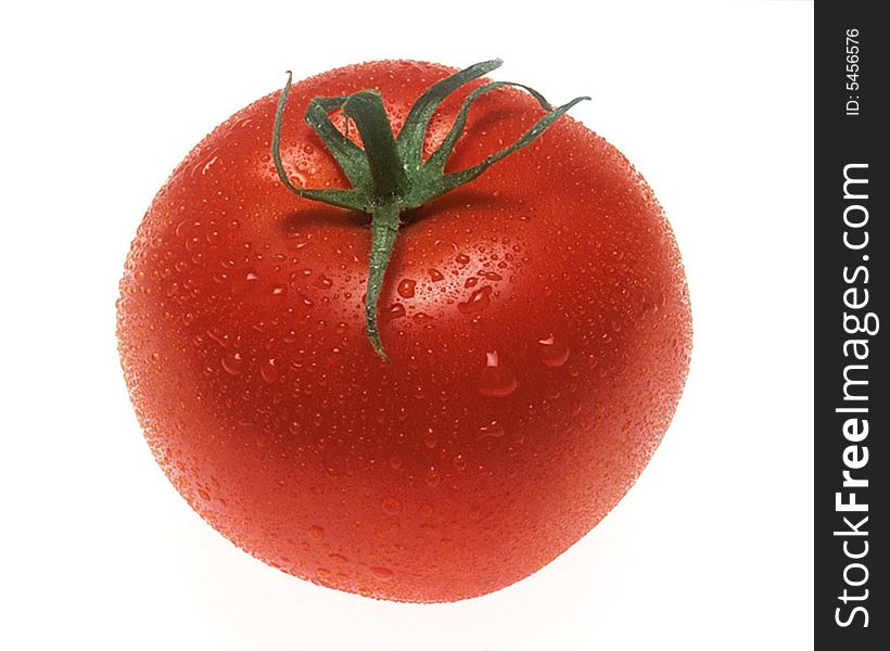 Red tomato on a white background with drops of water