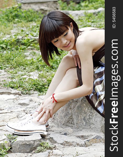 Girl sitting on the stone having a rest. Here is an ancient village of China. Girl sitting on the stone having a rest. Here is an ancient village of China.