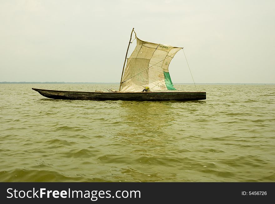 At Cienaga Grande de Santa Marta, Colombia, a fisherman is sailing across the lake in his wooden canoa. At Cienaga Grande de Santa Marta, Colombia, a fisherman is sailing across the lake in his wooden canoa.