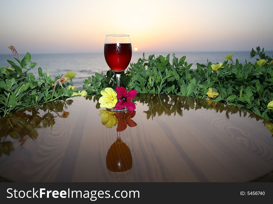 Cold glass of wine on the wood table on the sea sunrise. Cold glass of wine on the wood table on the sea sunrise