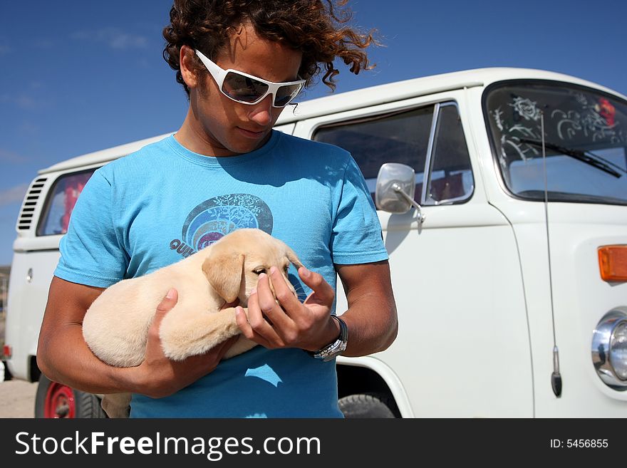 Young man holding his labrador puppy. Young man holding his labrador puppy