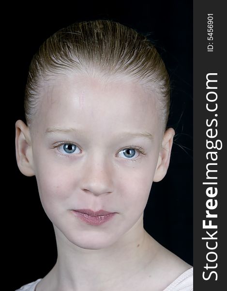A facial portrait of a blue eyed young girl with hair tied back. A facial portrait of a blue eyed young girl with hair tied back.