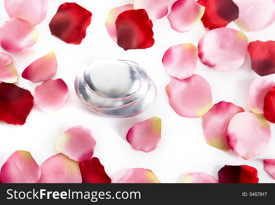 Pile of round pebbles with rose petals isolated on white background
