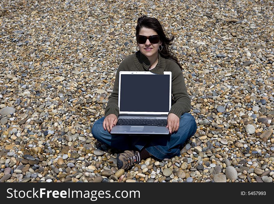 Young woman with laptop computer in beach