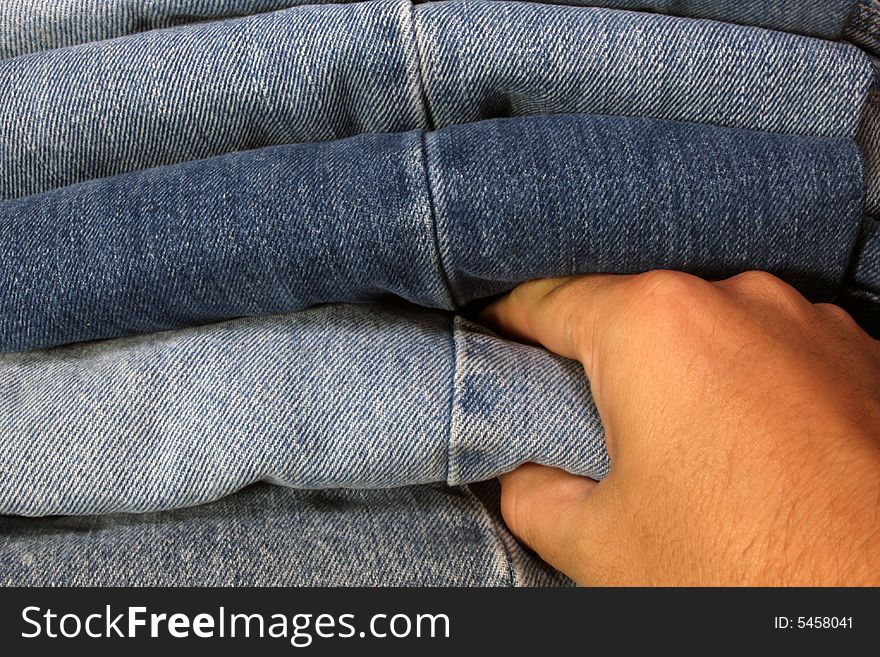 Someone picking out a pair of blue jeans. Someone picking out a pair of blue jeans