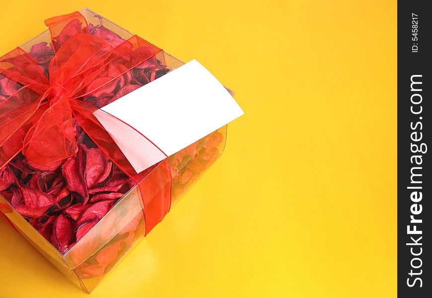 Red Potpourri gift with a white card, on a yellow background