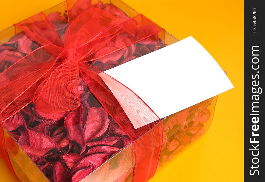 Red Potpourri gift with a white card, on a yellow background