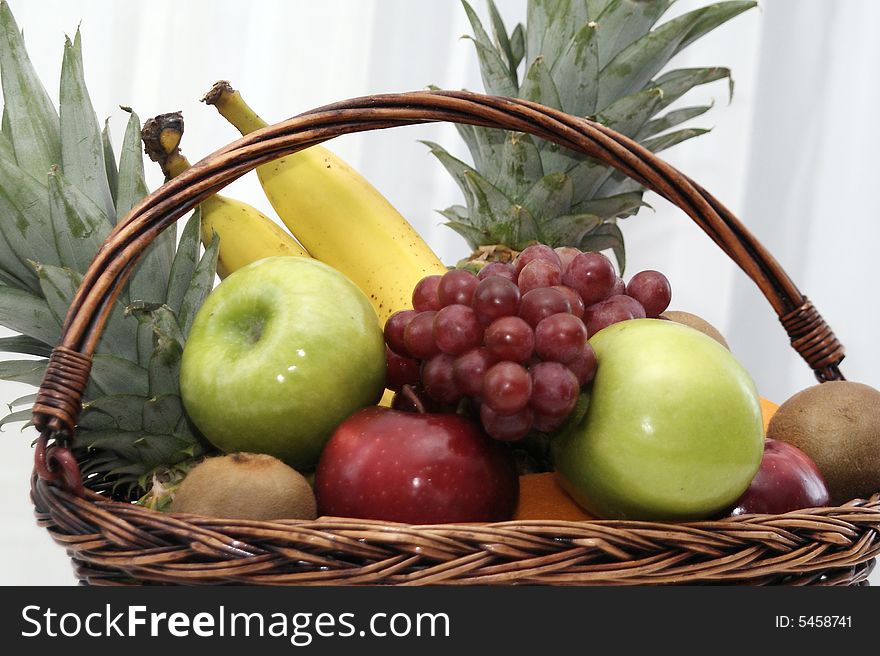 Detail of fruit basket with apples and grapes, bananas, pineapples. Detail of fruit basket with apples and grapes, bananas, pineapples